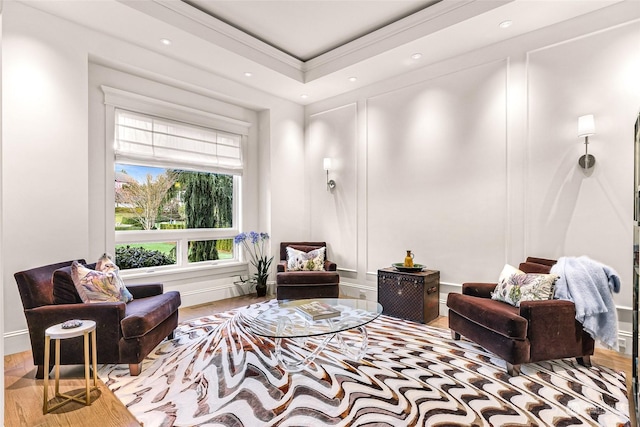 living area with a tray ceiling and wood-type flooring