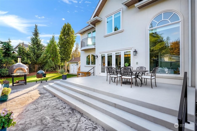 exterior space featuring a patio, a balcony, and exterior fireplace