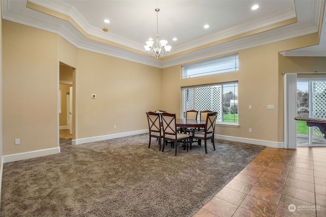 carpeted dining room featuring a raised ceiling, an inviting chandelier, and ornamental molding