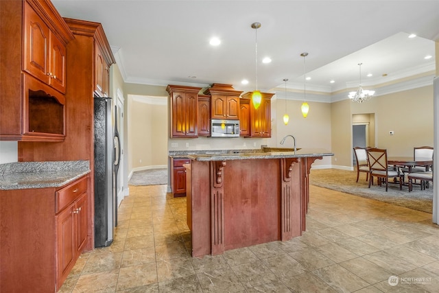 kitchen with pendant lighting, dark stone counters, a center island with sink, stainless steel appliances, and a chandelier