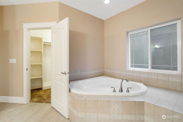 bathroom with a relaxing tiled tub and tile patterned floors