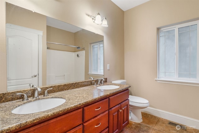 bathroom with tile patterned floors, a shower, vanity, and toilet