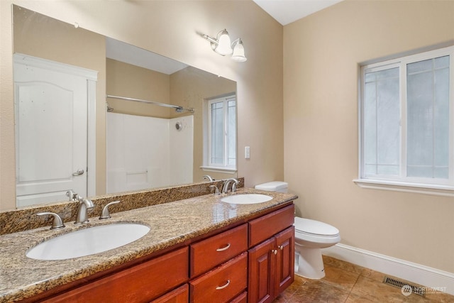 20086 Cherry Rd NW, Soap Lake, WA 98851 - full bath featuring toilet, double vanity, a shower, baseboards, and tile patterned floors