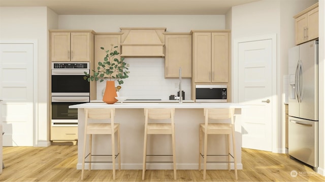 kitchen featuring a kitchen bar, premium range hood, stainless steel appliances, and light hardwood / wood-style flooring