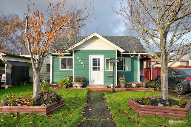 bungalow featuring a front lawn