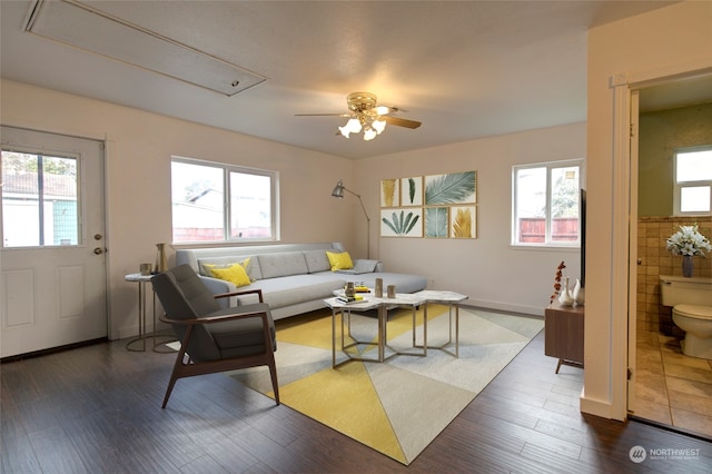 living room with ceiling fan, a healthy amount of sunlight, tile walls, and dark wood-type flooring