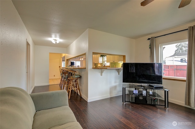 living room featuring ceiling fan and dark wood-type flooring