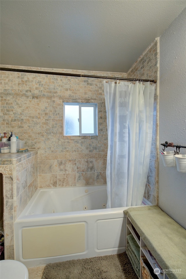 bathroom featuring a textured ceiling and shower / tub combo with curtain