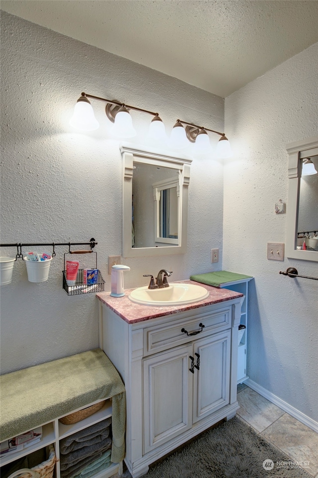 bathroom featuring tile patterned flooring, a textured ceiling, and vanity