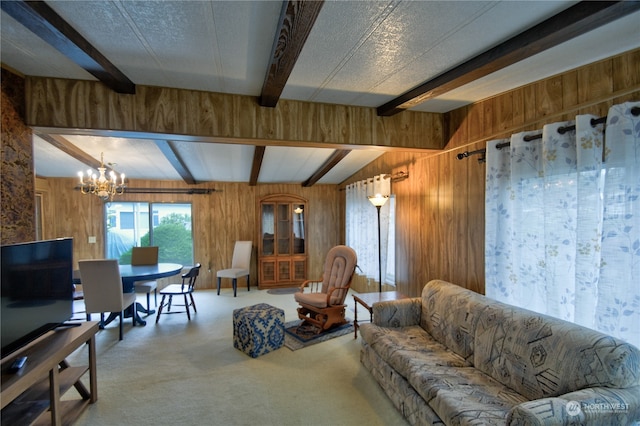 carpeted living room featuring beam ceiling, wood walls, a textured ceiling, and a notable chandelier