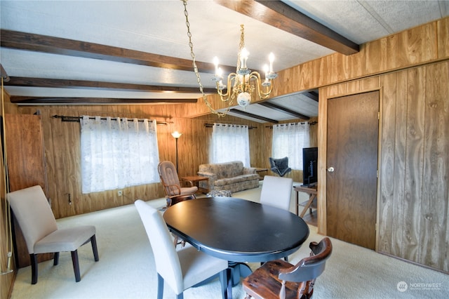 carpeted dining area featuring wood walls, beamed ceiling, and a chandelier