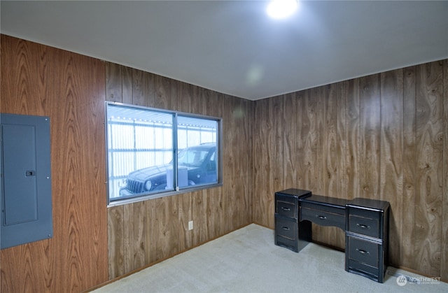 office with wood walls, light carpet, and electric panel