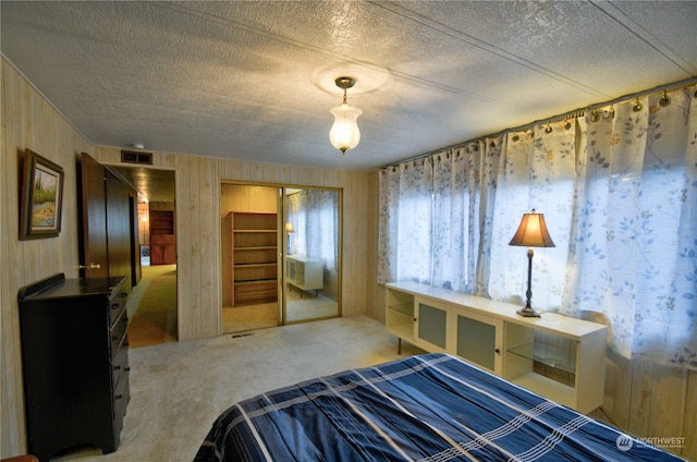 carpeted bedroom featuring a textured ceiling and a closet