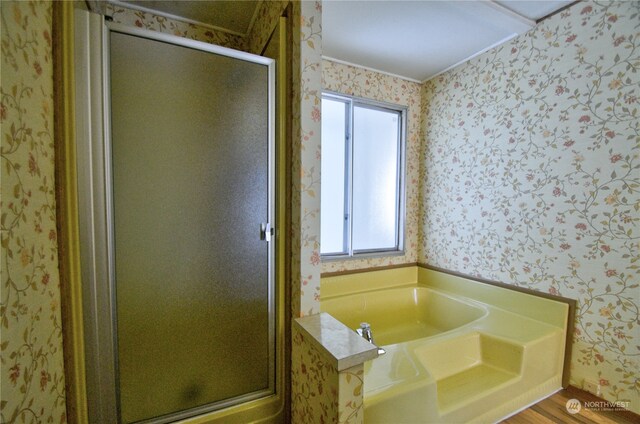 bathroom with hardwood / wood-style flooring and independent shower and bath