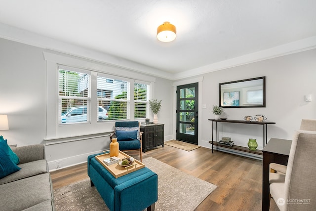 living room featuring hardwood / wood-style flooring, plenty of natural light, and crown molding