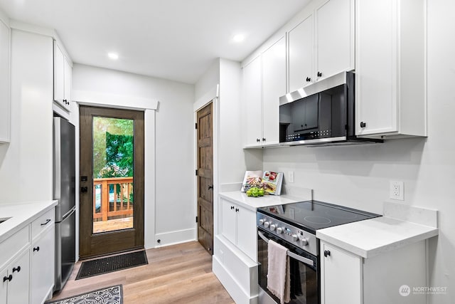 kitchen featuring white cabinets, light wood-type flooring, and appliances with stainless steel finishes