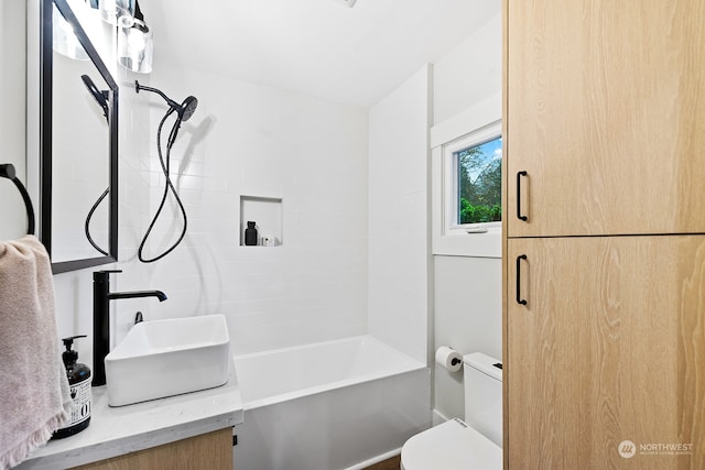 full bathroom featuring tiled shower / bath combo, toilet, and sink