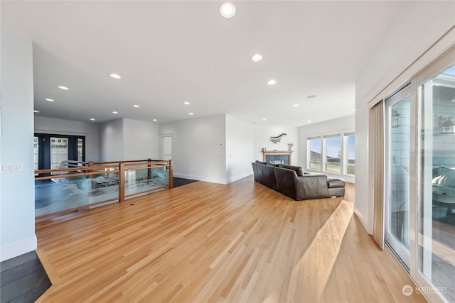 living room with a tiled fireplace, french doors, and light hardwood / wood-style floors