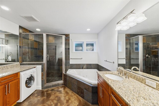 bathroom featuring vanity, plus walk in shower, and washer / clothes dryer