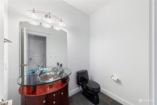 bathroom with toilet, vanity, and tile patterned floors