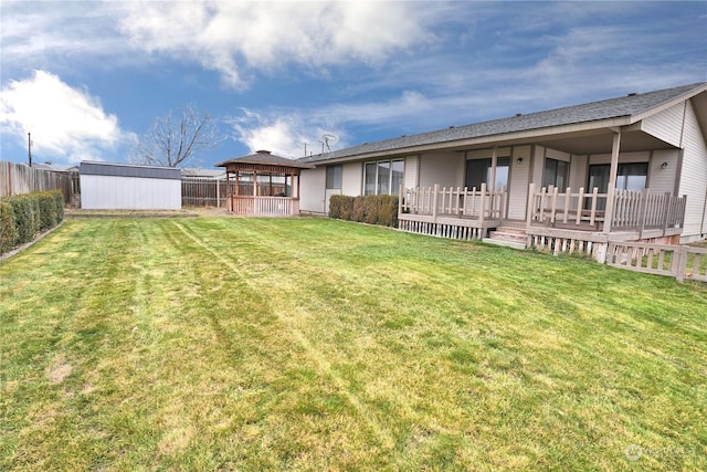 back of property featuring a gazebo, a shed, and a lawn