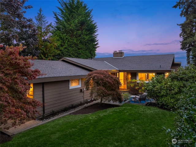 back house at dusk with a yard