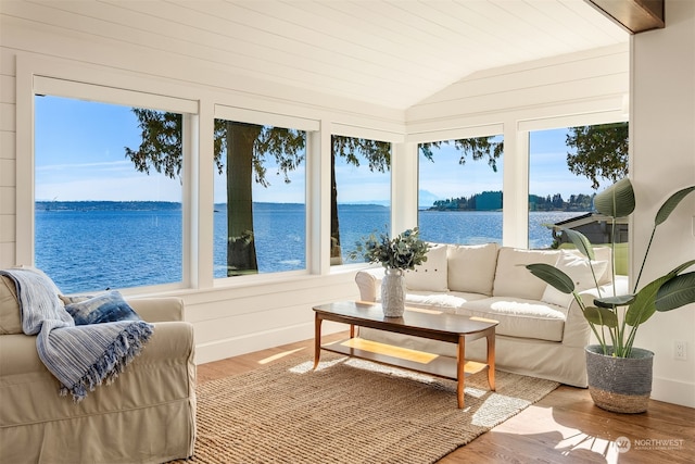 sunroom featuring plenty of natural light, a water view, and vaulted ceiling