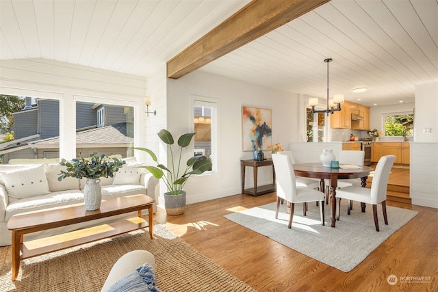 dining space featuring light wood-type flooring, wood ceiling, and an inviting chandelier