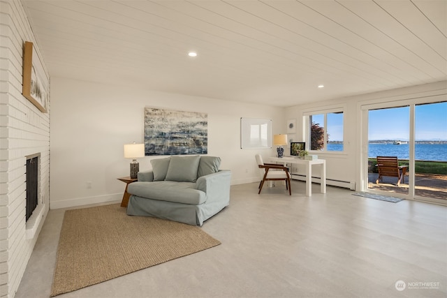 living room featuring a water view, a baseboard heating unit, and a brick fireplace