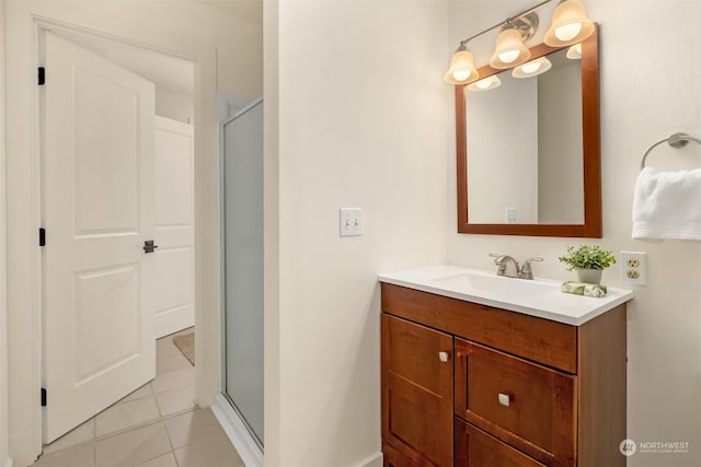 bathroom featuring tile patterned flooring, vanity, and a shower with shower door