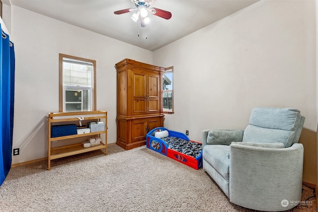 living area featuring ceiling fan, plenty of natural light, and carpet