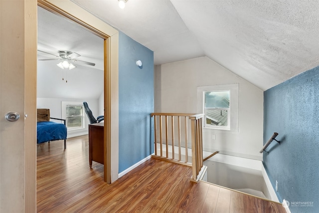 bonus room featuring hardwood / wood-style floors, a textured ceiling, ceiling fan, and lofted ceiling