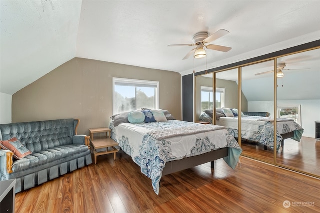 bedroom with ceiling fan, a closet, lofted ceiling, and hardwood / wood-style flooring