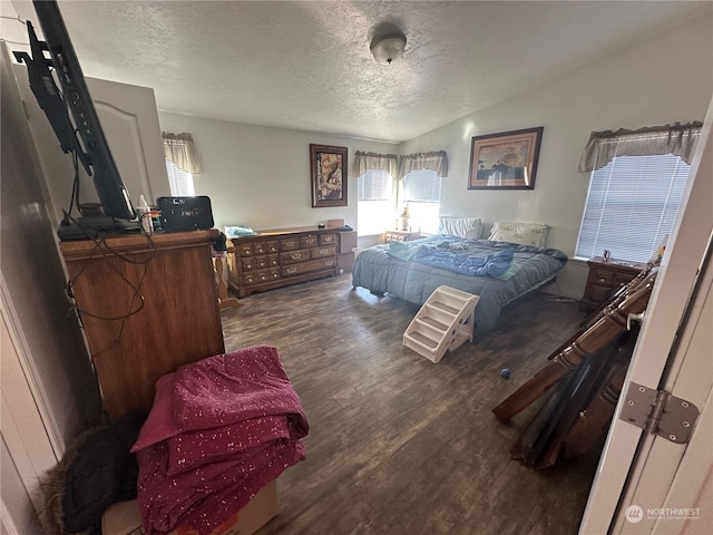 bedroom featuring a textured ceiling, vaulted ceiling, and dark wood-type flooring