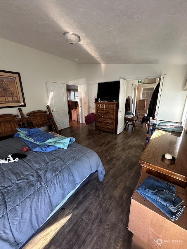 bedroom featuring dark hardwood / wood-style flooring and a textured ceiling