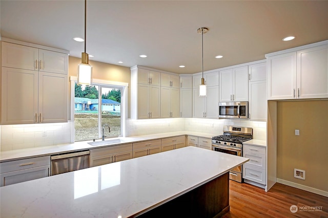 kitchen featuring white cabinetry, sink, pendant lighting, and appliances with stainless steel finishes