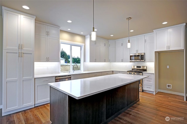 kitchen featuring white cabinets, light wood-type flooring, sink, and appliances with stainless steel finishes