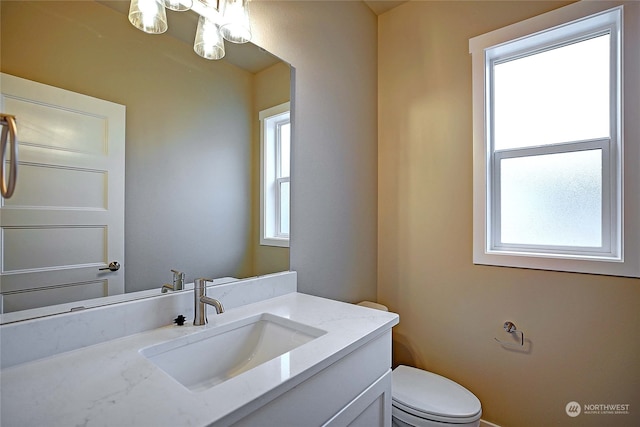 bathroom with vanity, toilet, and a wealth of natural light