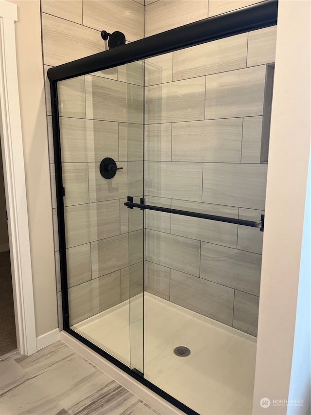 bathroom with a shower with door