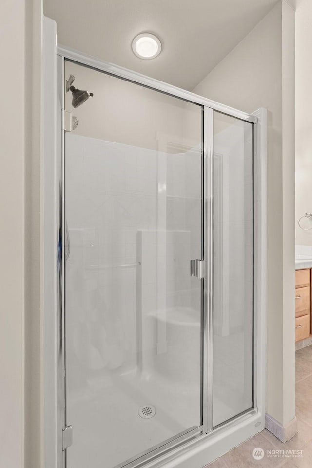 bathroom with an enclosed shower and tile patterned floors