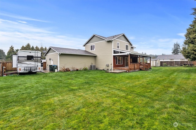 rear view of house featuring a wooden deck, a yard, and central air condition unit