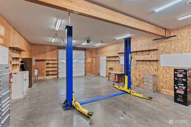 interior space with a garage door opener and wood walls