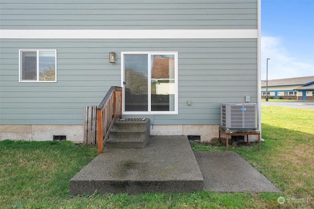 doorway to property featuring central AC and a lawn