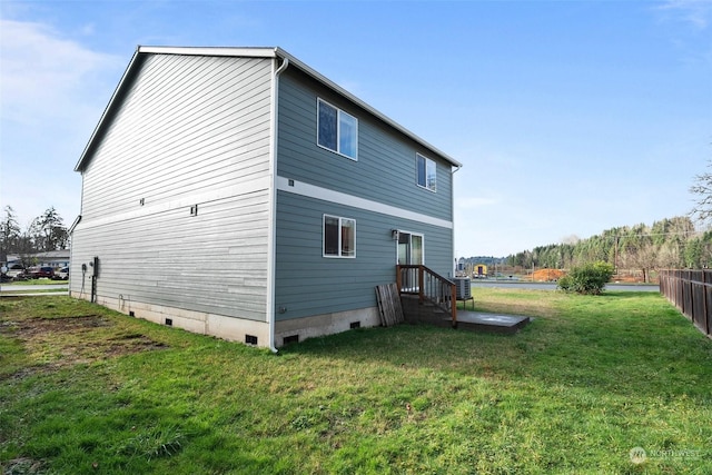 rear view of property featuring a yard and central AC