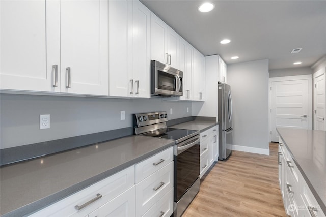 kitchen with white cabinetry, appliances with stainless steel finishes, and light wood-type flooring