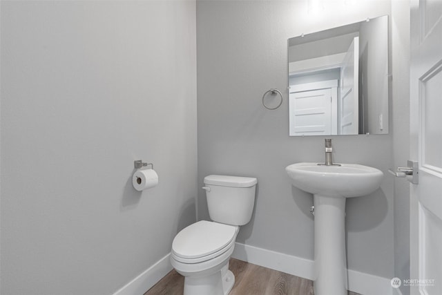 bathroom with hardwood / wood-style flooring and toilet