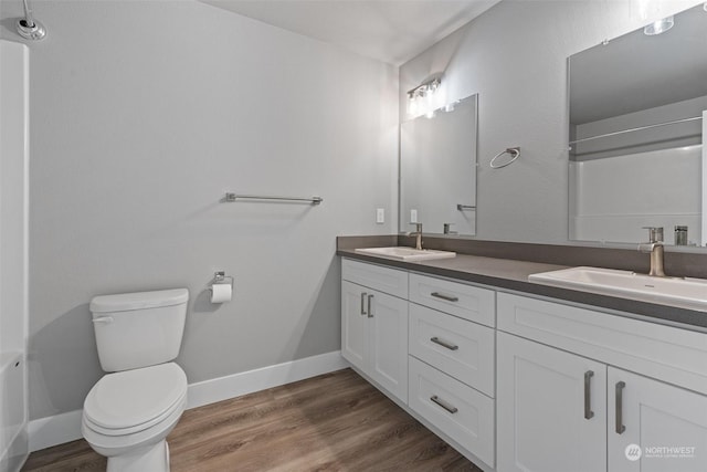 bathroom with vanity, toilet, and hardwood / wood-style floors