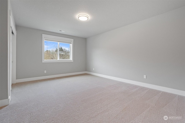 unfurnished room featuring carpet floors and a textured ceiling