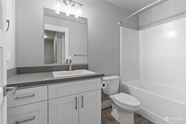 full bathroom with vanity, hardwood / wood-style floors, shower / bathtub combination, and toilet