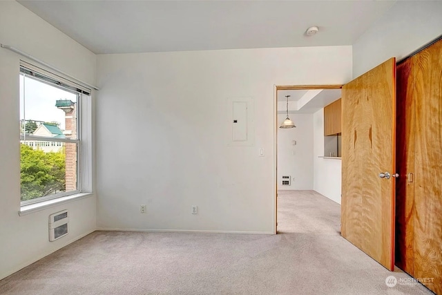 empty room featuring electric panel and light carpet